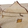 authentic-beni-ourain-cream-tribal-rug Close-up of the plush wool texture and brown stitched diamond pattern on a Moroccan rug.