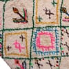 authentic-handwoven-moroccan-tribal-rug Detailed close-up of bright pink and blue diamond motifs on a cream wool background.