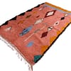 bohemian-moroccan-coral-area-rug Overhead image showing symmetrical tribal diamond patterns on a wool rug.