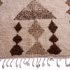 bohemian-moroccan-wool-area-rug Slight angled perspective of ivory and brown geometric area rug on white background.