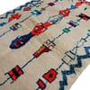 cream-blue-geometric-moroccan-wool-rug Traditional Moroccan rug with red and blue motifs angled view