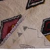 handmade-moroccan-berber-wool-rug-colorful-geometric Side border detail displaying zigzag tribal line pattern along the left edge.