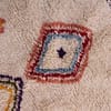 premium-handwoven-berber-rug-with-fringes Side border detail showing vertical arrow-like tribal patterns along the edges.