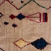 thick-pile-berber-moroccan-rug Close-up detail of colorful diamond shapes woven into the soft ivory background.
