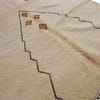 traditional-cream-beni-ourain-rug Angled perspective of a minimalist Moroccan area rug with geometric motifs.