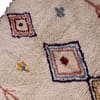 tribal-moroccan-rug-with-vibrant-symbols Bottom section view featuring the lower diamond design and soft ivory wool texture.