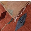 vibrant-berber-tribal-pink-carpet Close-up of fringed edge and handwoven details of a Moroccan boho carpet.