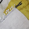 artisan-berber-area-rug-cream-base Side angle of handmade Moroccan Berber rug highlighting thickness and wool texture.