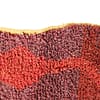 authentic-moroccan-wool-rug-modern-tribal Close-up view of a handmade Moroccan Berber rug showing red and green abstract patterns and thick wool texture.