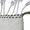 beni-ourain-wool-rug Corner detail of white Beni Ourain rug with green, brown, and yellow patterns.