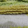 black-and-white-berber-rug Close-up of Beni Ourain rug texture showing white wool and green, brown, and yellow details.