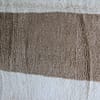 bohemian-moroccan-area-rug Folded Moroccan Beni Ourain rug showing white base and colorful geometric design.