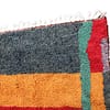 colorful-azilal-style-moroccan-area-rug Top section close-up showing multicolor square pattern and horizontal stripe details.