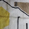 custom-moroccan-handmade-area-rug Wide shot of contemporary Berber area rug with bold yellow centerpiece.