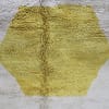 luxury-berber-wool-rug-minimalist Close-up of Moroccan wool rug texture showing cream pile and yellow geometric shape.