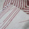 minimalist-bedroom-beni-ourain-rug A bedroom rug with a simple design, white base, and light pink stripes. Details on the back of the rug.