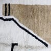 modern-moroccan-rug-yellow-brown-black Detailed view of handwoven Berber rug with black lines and mustard yellow design.