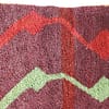 red-beni-ourain-style-rug-geometric-pattern Side angle view of the Moroccan Berber rug highlighting its thickness and handwoven texture.