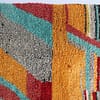 thick-pile-moroccan-abstract-area-rug Middle section detail highlighting textured wool and color contrast between orange and charcoal.