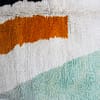 moroccan-berber-rug-cream-base-geometric-design.jpg Side angle view of Moroccan rug highlighting thickness and wool texture