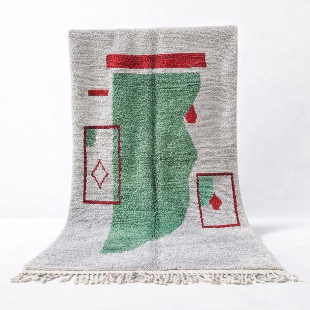 Abstract geometric rug with green features Full view of the Moroccan rug centered against a white background, showing the complete green and red geometric design.