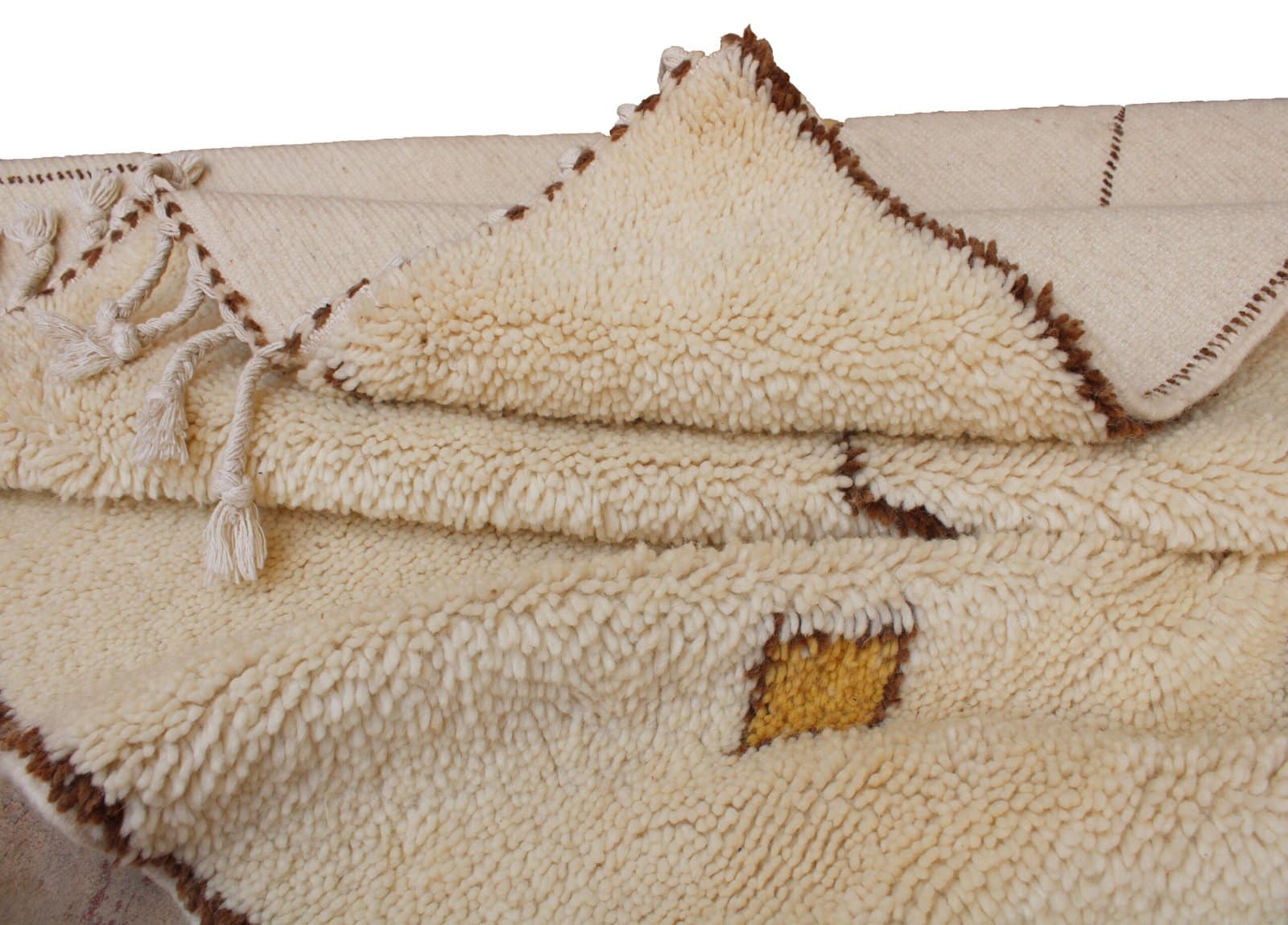 authentic-beni-ourain-cream-tribal-rug Close-up of the plush wool texture and brown stitched diamond pattern on a Moroccan rug.