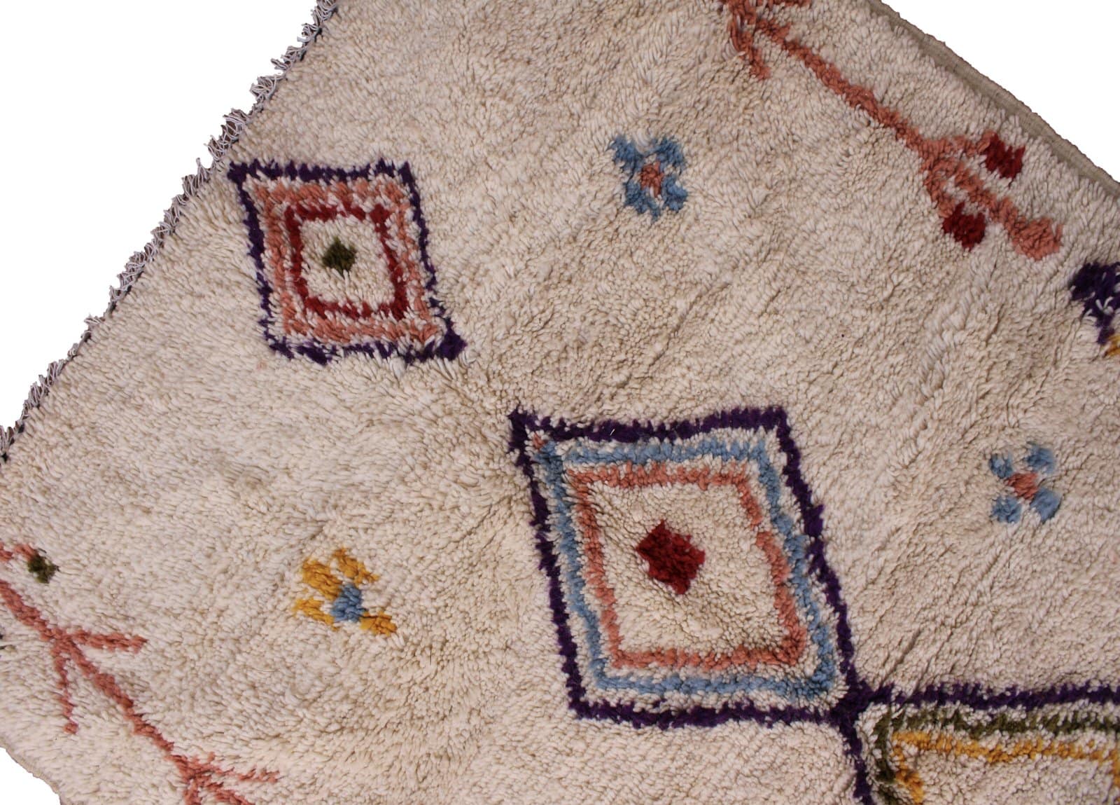 bohemian-moroccan-berber-shag-rug Straight vertical display of ivory Moroccan rug showing three central stacked diamond patterns in red, blue, yellow, and purple.