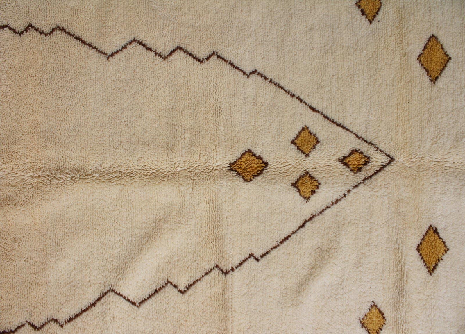 cream-geometric-moroccan-wool-rug-handwoven Top-down view of a cream Moroccan wool rug showing symmetrical diamond designs.