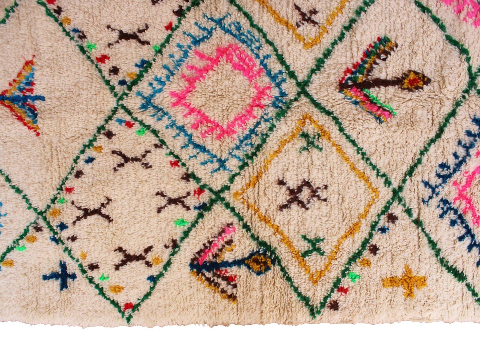 geometric-diamond-moroccan-wool-carpet Top-down view of a vibrant Moroccan area rug with pink, blue, and yellow diamond shapes.