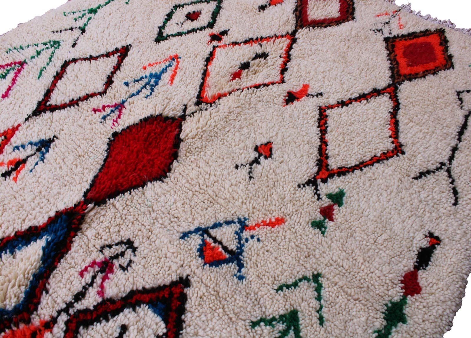 handmade-moroccan-diamond-wool-rug Angled view of cream Moroccan rug with multicolor tribal symbols