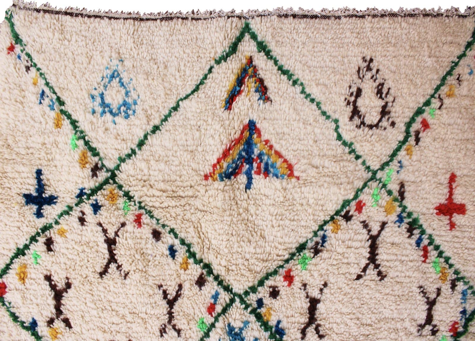 moroccan-berber-rug-with-green-lattice-design Close-up of the rug’s fringed edge and handcrafted weaving details.