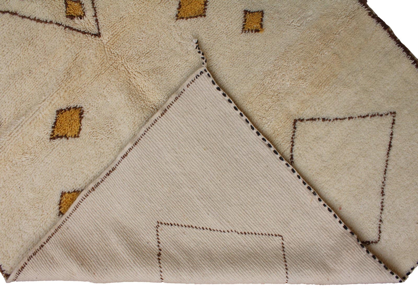 neutral-moroccan-wool-area-rug-with-diamonds Partial side view showing the rug’s soft texture and subtle brown border lines.