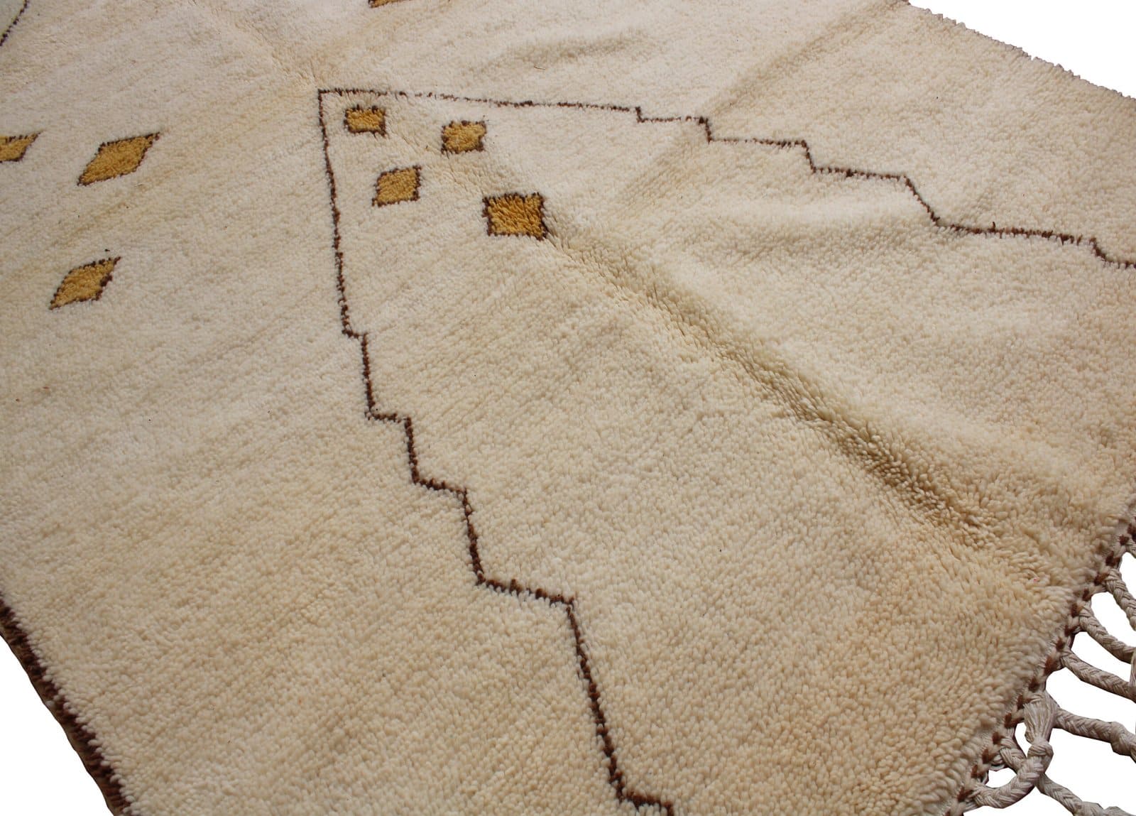 traditional-cream-beni-ourain-rug Angled perspective of a minimalist Moroccan area rug with geometric motifs.