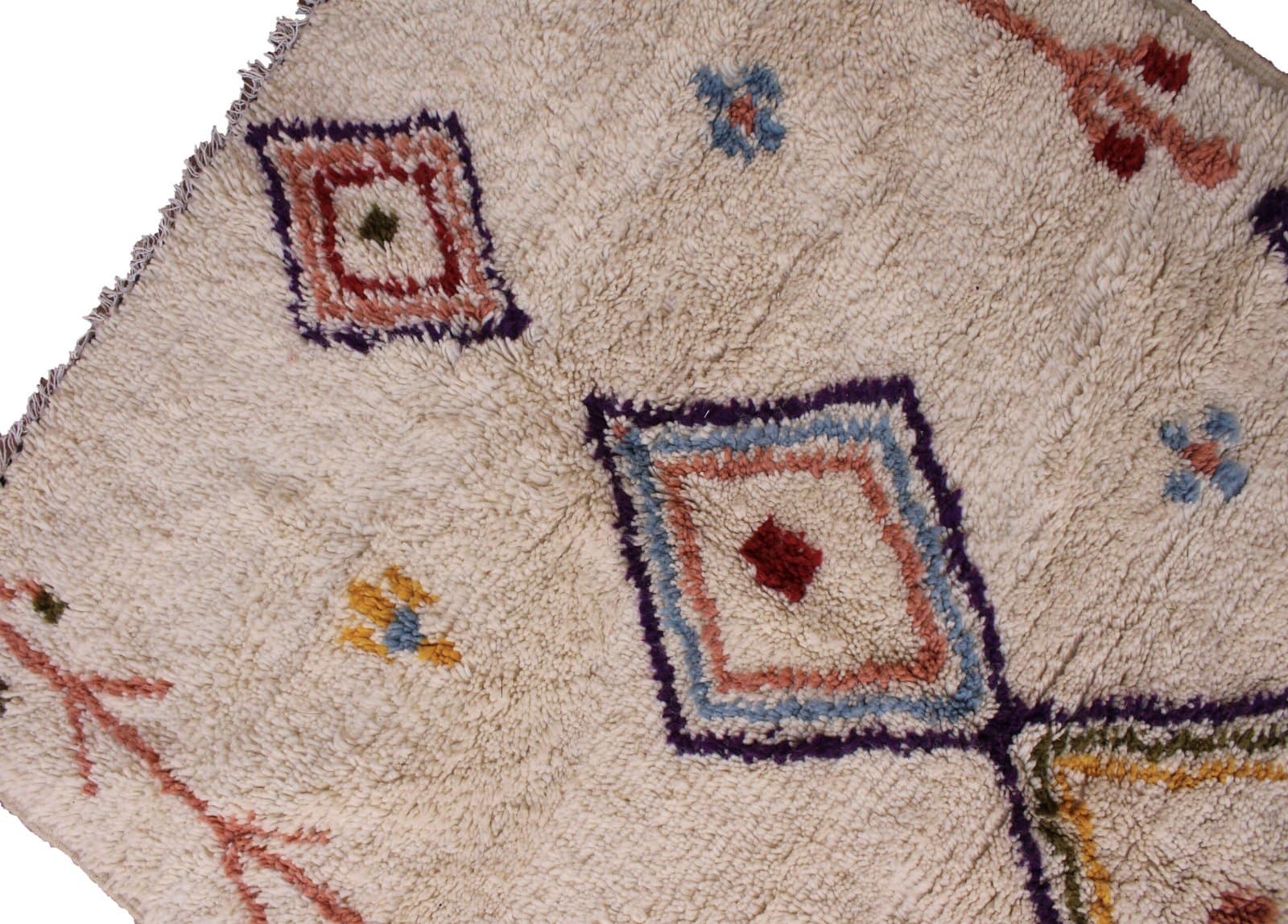tribal-moroccan-rug-with-vibrant-symbols Bottom section view featuring the lower diamond design and soft ivory wool texture.