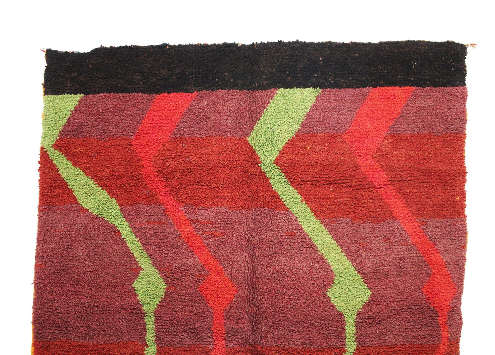 artisan-berber-rug-handwoven-morocco Corner detail close-up highlighting the rich red tones and dense wool craftsmanship.