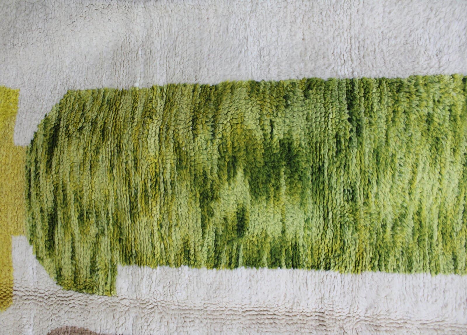 artisan-made-wool-rug-morocco Handmade white Beni Ourain rug with green, brown, and yellow Berber design – complete view.