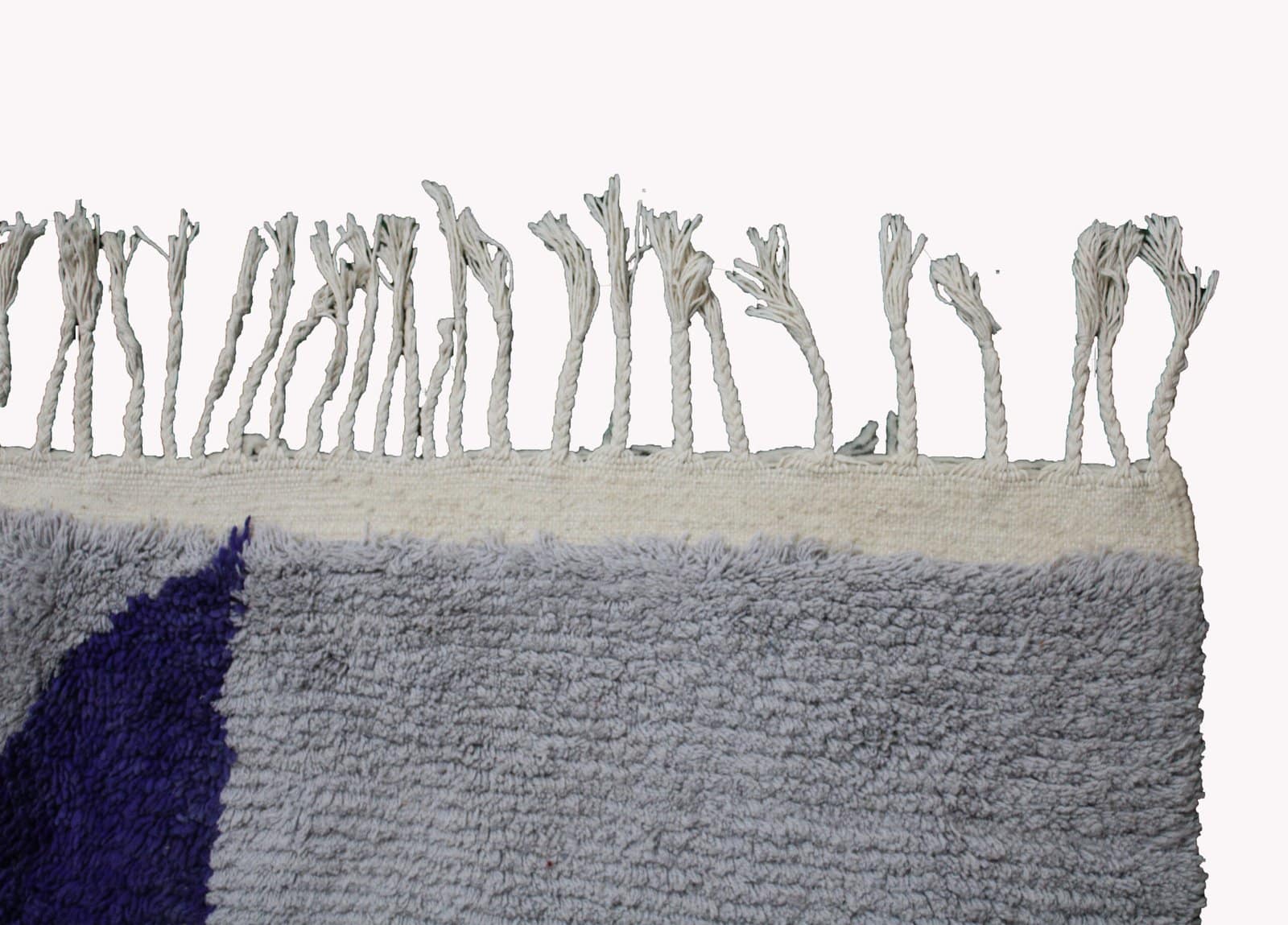 contemporary-boho-area-rug-geometric-pattern Bottom section close-up displaying the cream tassels and lower purple stripe detail.