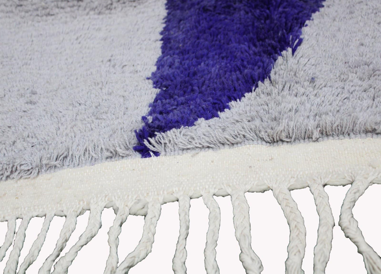handmade-berber-rug-cream-purple-modern-style close-up displaying the cream tassels and lower purple stripe detail.