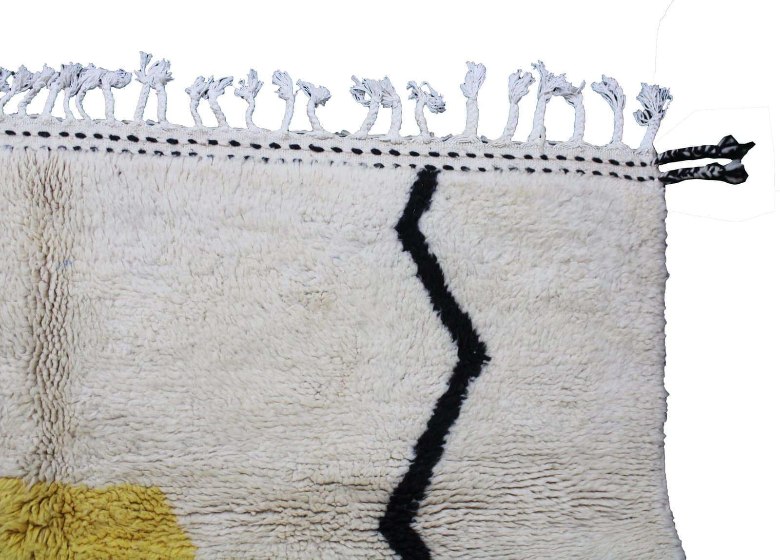 handmade-moroccan-wool-rug-modern-design Angled view of cream Moroccan wool rug with modern yellow and black design.