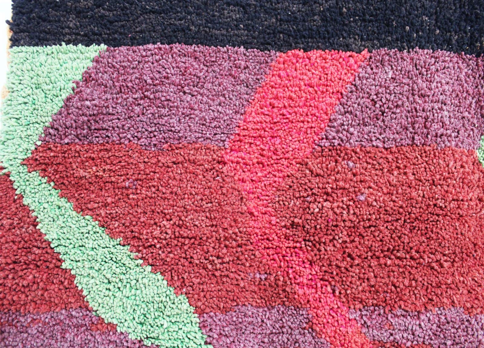 large-moroccan-tribal-rug-red-black Mid-distance view of the rug showing balanced abstract tribal patterns across the surface.