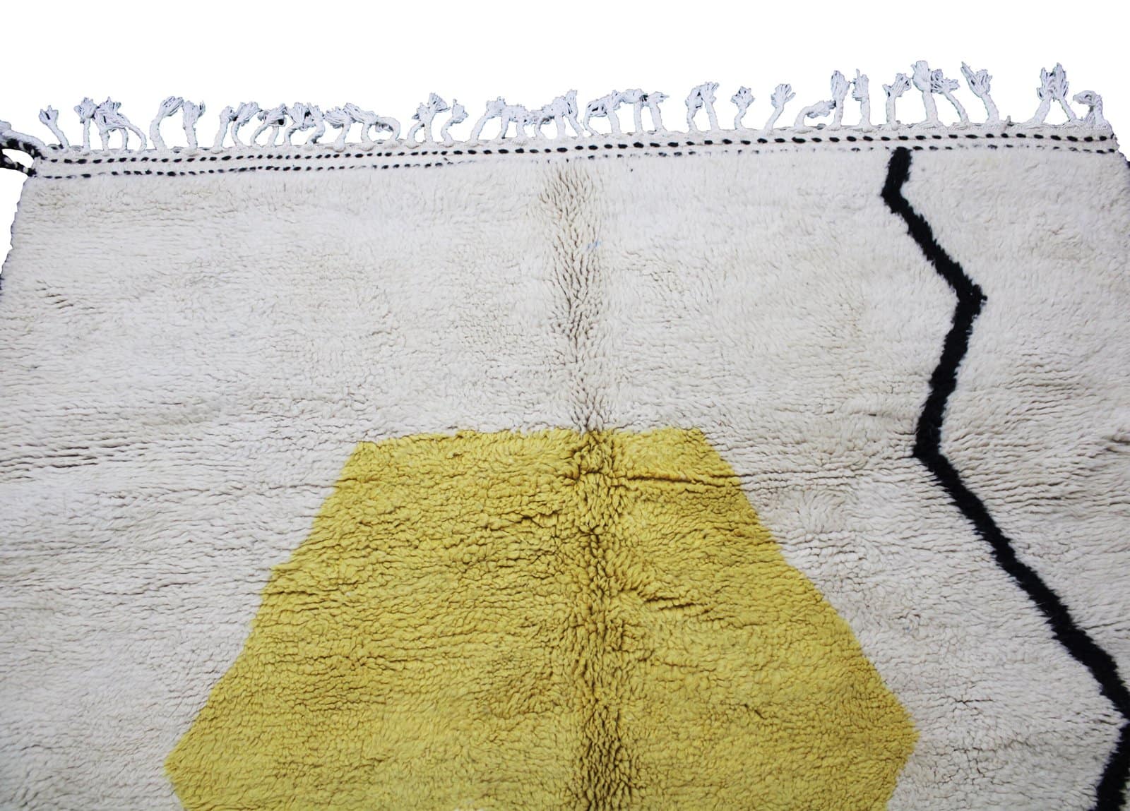 moroccan-abstract-berber-rug-cream-yellow Edge detail of artisan Berber rug showing fringe and woven finish.