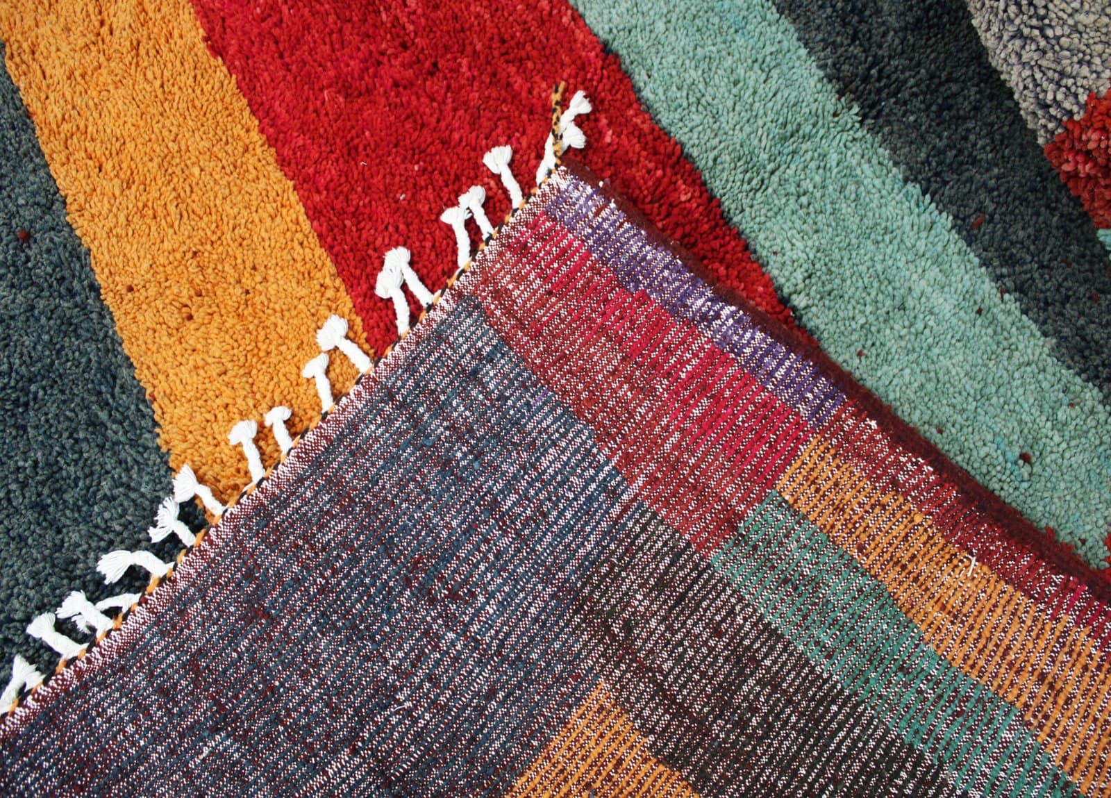multicolor-berber-wool-living-room-rug Fringe detail showing hand-knotted tassels along the rug edge.
