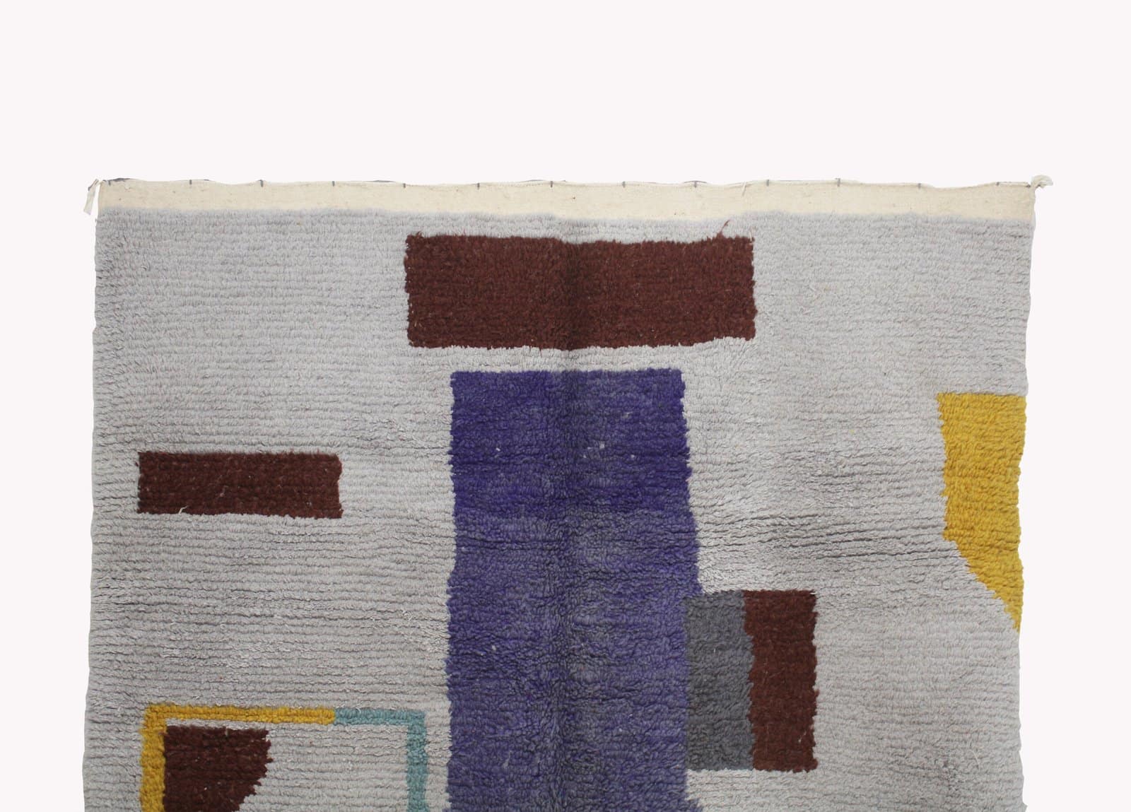 neutral-tone-berber-rug-with-geometric-shapes Wide shot of the entire Moroccan rug showing fringe tassels and abstract geometric patterns.