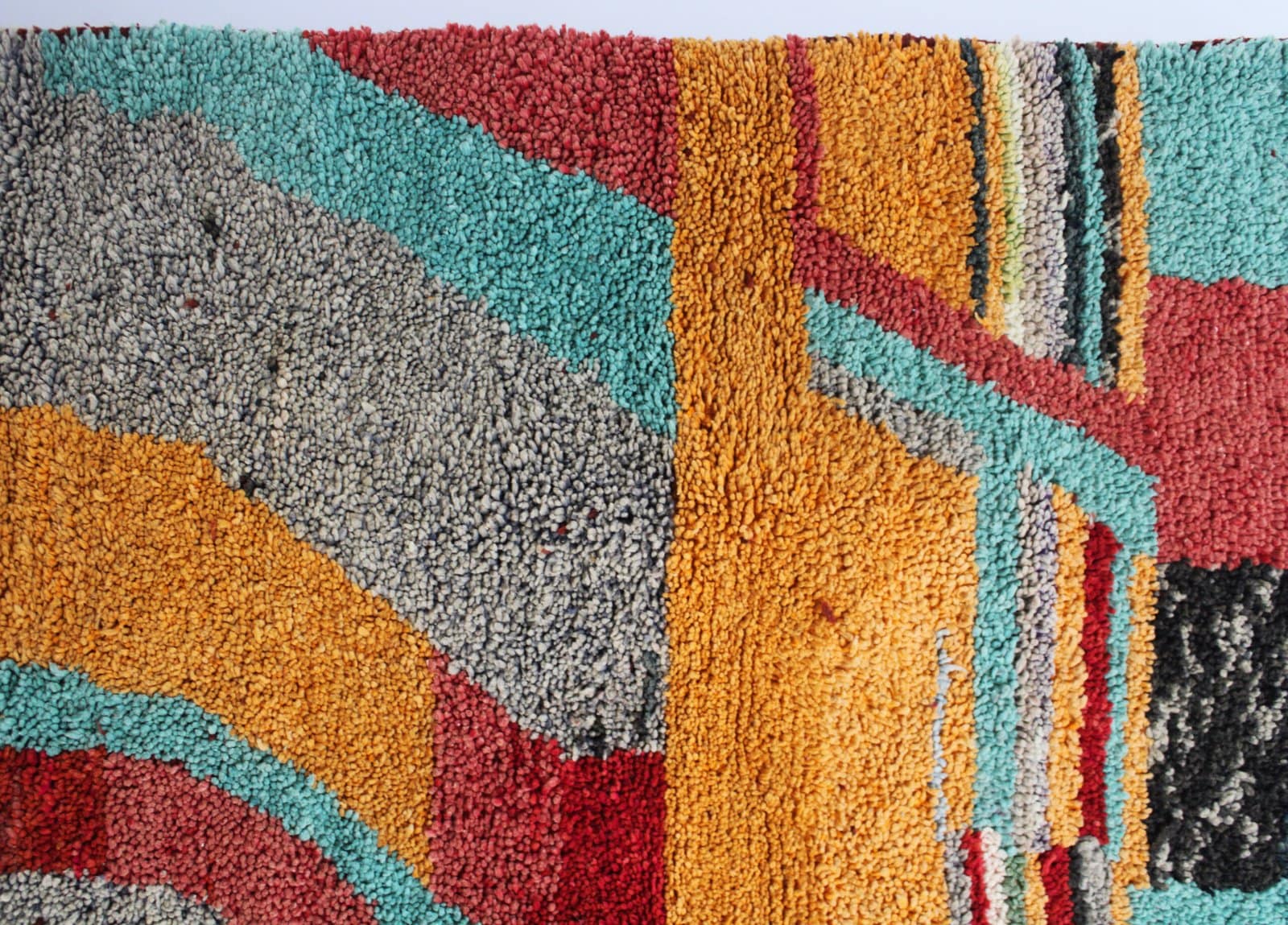 thick-pile-moroccan-abstract-area-rug Middle section detail highlighting textured wool and color contrast between orange and charcoal.