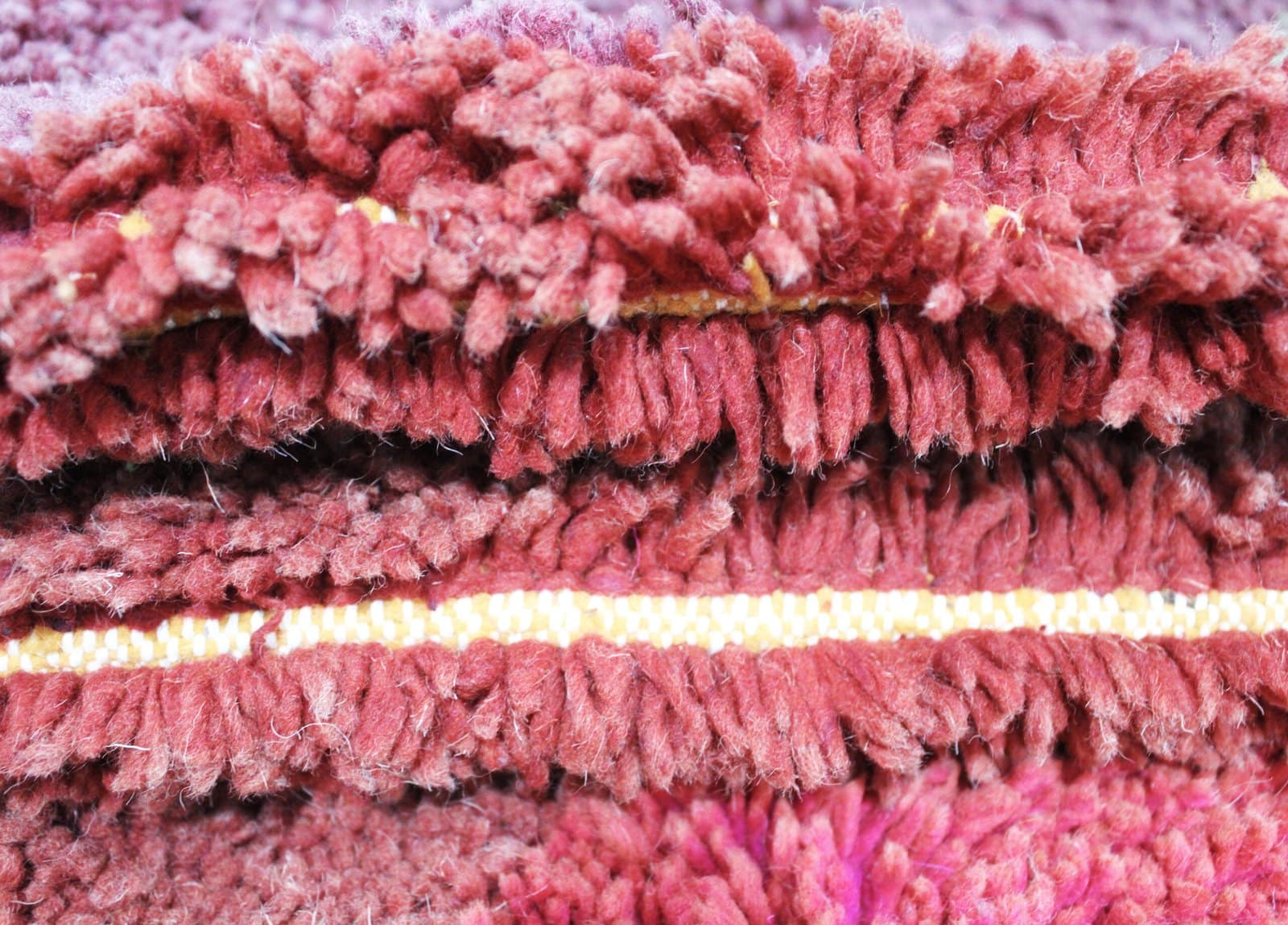 traditional-berber-wool-rug-colorful-design Detailed texture close-up of the soft wool pile and woven fibers of the Moroccan rug.