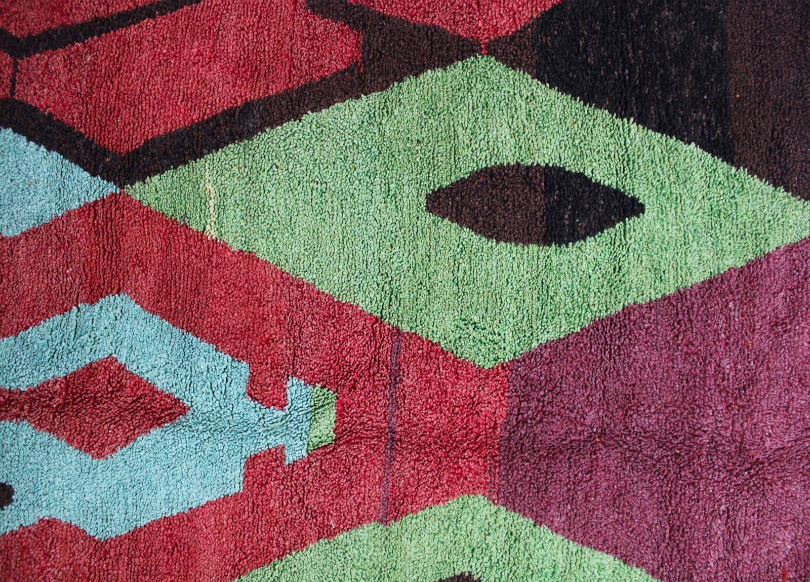 colorful-azilal-rug-geometric-berber-artisan Moroccan rug displayed from a diagonal angle showing depth and perspective