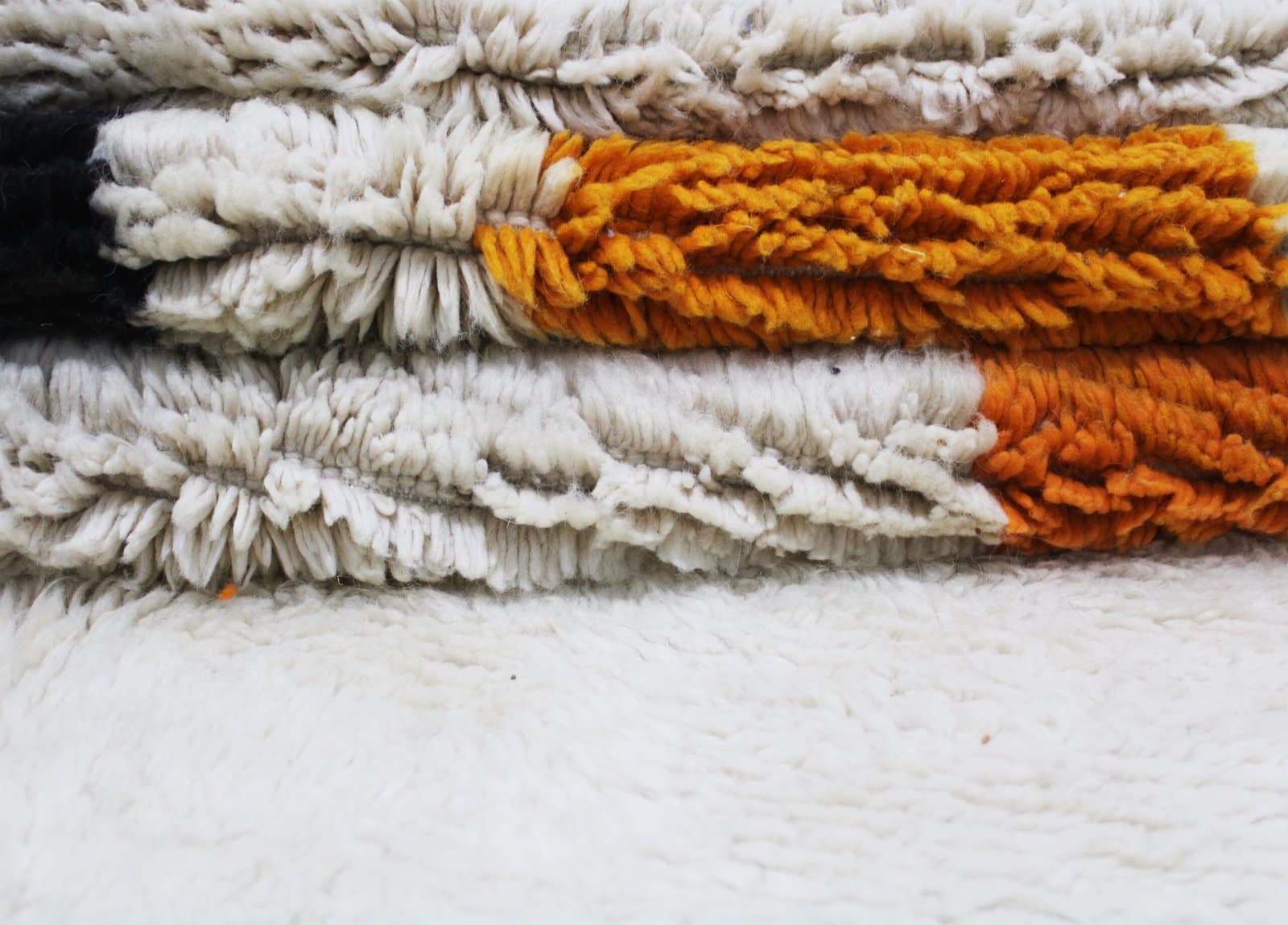 minimalist-moroccan-rug-abstract-geometric-pattern Partial close-up focusing on black and orange shapes in the rug