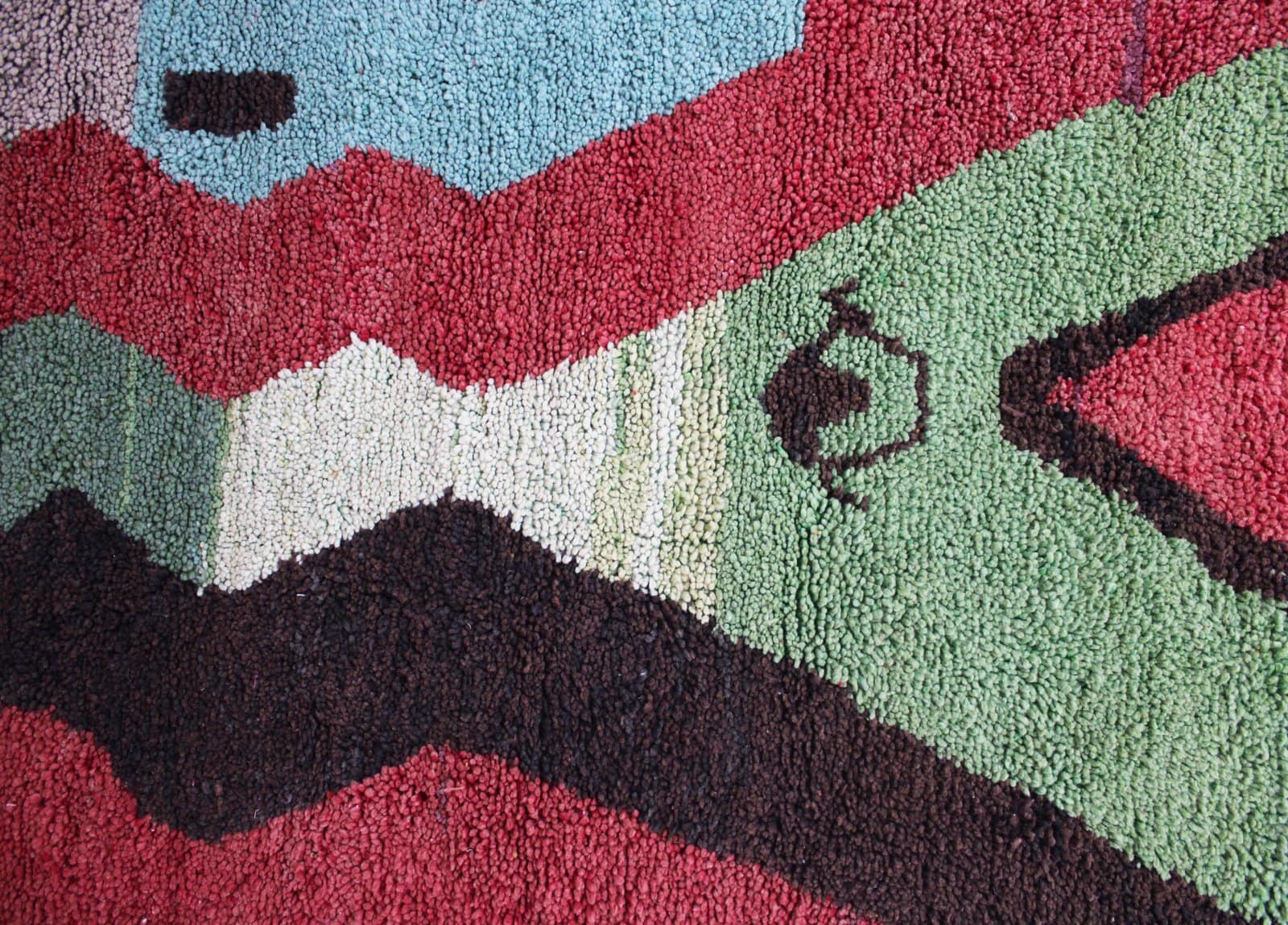 moroccan-handwoven-rug-colorful-diamond-pattern Side angle view of Moroccan rug highlighting thickness and texture