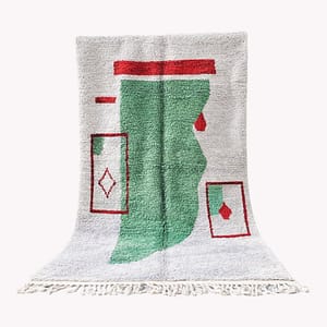 Full view of the Moroccan rug centered against a white background, showing the complete green and red geometric design.