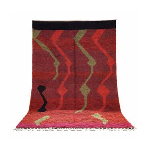 Full view of a large Moroccan wool rug displayed against a white background with bold red, olive green, and black geometric designs.